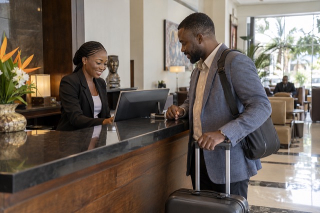 Illustration d’une réceptionniste accueillant un voyageur dans un hôtel en RDC.